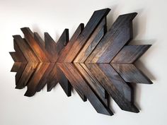 a wooden wall decoration with an arrow shaped design