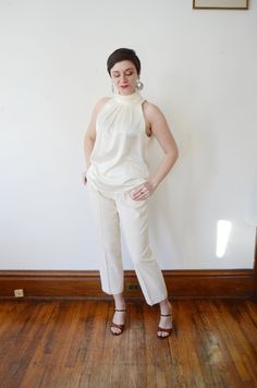 "Description: Shimmery off white blouse that buttons up the back of the neck with crystal buttons. Measurements of garment, allow space for fit. Bust: 43\" Length: 25\" I take my measurements flat, and double for circumference. Tag: Chaus Fabric: Silky polyester Condition: Excellent Follow along on instagram @lovecharlesvintage" Elegant Beige Sleeveless Blouse, Elegant Sleeveless Blouse For Day Out, Cream Sleeveless Formal Top, Cream Sleeveless Top For Formal Occasions, Cream Sleeveless Top For Night Out, Elegant Cream Stretch Blouse, Cream Sleeveless Evening Top, Beige Stretch Blouse For Work, Sleeveless Stretch Blouse For Formal Occasions