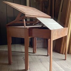 an old wooden desk with a folding top