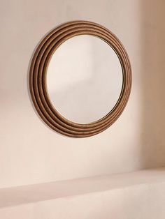 a round mirror hanging on the side of a wall