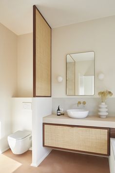 a bathroom with a sink, toilet and mirror