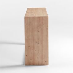 a wooden box sitting on top of a white floor next to a shadowless wall