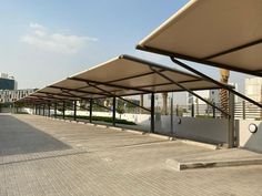 an empty parking lot in front of a large building with lots of white awnings