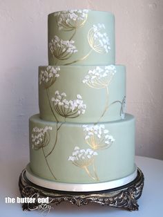 a three tiered cake with white flowers on it