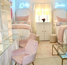 two beds in a room with pink chairs and white sheets on the bed, next to each other