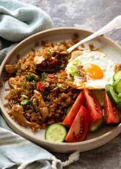 a bowl filled with rice, meat and veggies on top of a table