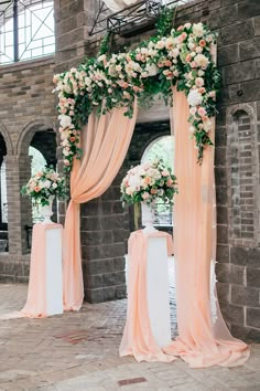 an archway decorated with pink and white flowers