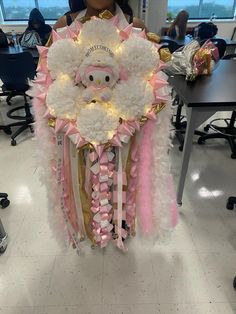 a woman is holding a pink and white decoration