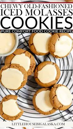 A cooling rack holds Old-Fashioned Iced Molasses Cookies adorned with vanilla icing. A small bowl and spoon with icing are nearby. A checkered cloth is partially visible in the background, and a couple of cookies rest on the white surface, hinting at the perfect blend of spices within. Old Fashion Molasses Cookies Soft, Iced Molasses Cookies, Old Fashioned Molasses Cookies, Alaskan Food, Alaska Food, Chewy Molasses Cookies, Molasses Cookies Recipe, Easy Holiday Treats, How To Stack Cakes