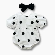 Introducing our charming Black Polka Dot Baby Romper, a must-have for your little one's wardrobe. This adorable romper features a white base with an all-over black polka dot pattern, adding a touch of playful elegance to their outfit. Designed with short sleeves and a square neckline, this romper is both stylish and comfortable. The buttons in the back make it easy to put on and take off, ensuring hassle-free dressing for busy parents. The cinched elastic at the legs provides a secure and comfor Black Cotton Onesie For Spring, Playful White Fitted Jumpsuits And Rompers, Fitted White Bubble Romper For Playtime, White Fitted Bubble Romper For Playtime, White Fitted Casual Bubble Romper, Spring Cotton Black Onesie, Spring Black Cotton Onesie, White Baby Outfit, White Playful Fitted Bubble Romper