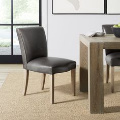 a dining room table with two chairs and a bowl of fruit