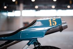 a close up of the handlebars on a blue and yellow bike in a parking garage