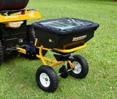 a yellow and black lawn mower sitting in the grass