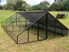 a chicken coop in the middle of a grassy field