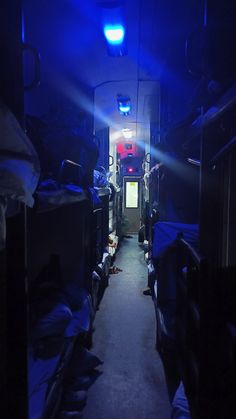 the inside of a small room with bunk beds and blue lights shining down on it