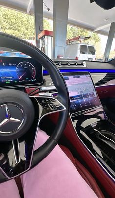 the interior of a car with pink leather and steering wheel, dashboard, and electronic display