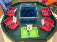 a green table topped with red and blue trays filled with diced numbers sitting on top of each other