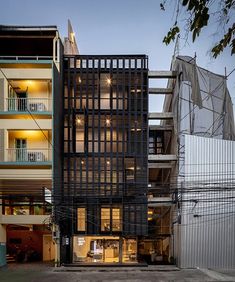 an apartment building with multiple levels and balconies on the second floor is lit up at night