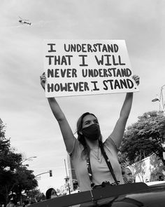 a woman holding up a sign that says i understand that i will never understand how it stands