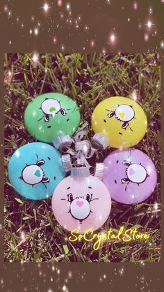 four ornaments with faces on them sitting in the grass