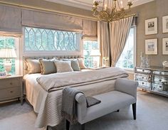 a bedroom with a large bed and chandelier