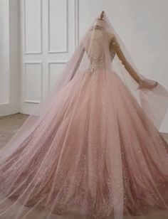 a dress on display in a room with white walls and wooden floors, wearing a long veil