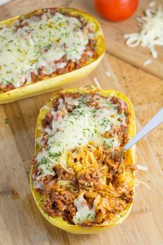 two stuffed spaghetti boats on a cutting board