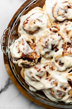 cinnamon rolls with icing in a glass bowl