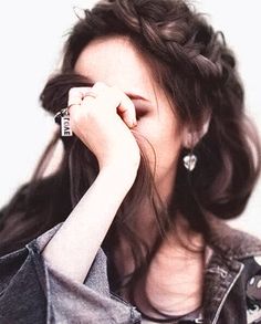 black and white photograph of a woman holding her hand to her face while wearing a denim jacket