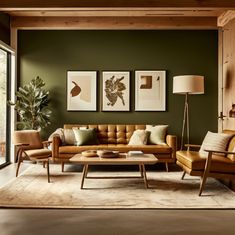 a living room with green walls and leather furniture in the center, two framed pictures on the wall