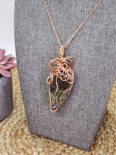 Unveil the magic of iridescent hues with this exquisite Rainbow Labradorite Pendant, meticulously handcrafted with precision wire-wrapping in elegant copper. Each angle reveals a kaleidoscope of color, making it a mesmerizing centerpiece to any ensemble. The artful spirals and curves of the copper wire enhance the stone's natural allure, presenting a one-of-a-kind accessory that's more than just jewelry; it's wearable art. Perfect for those who appreciate the unique touch of artisanal craftsmanship, this pendant promises to be an enchanting addition to your collection or a cherished gift for someone special. Embrace the enigmatic beauty of labradorite and let this necklace be a testament to your impeccable taste. You can follow me on social media: Facebook, Etsy, Instagram, Pinterest, and Unique Hand Wrapped Moss Agate Necklace, Hand Wrapped Wire Necklaces For Gifts, Hand Wrapped Wire Necklace For Gift, Mystical Wire Wrapped Jewelry For Gifts, Artisan Spiral Wire Wrapped Necklaces, Bohemian Moss Agate Jewelry Wire Wrapped, Artisan Wire Wrapped Spiral Necklace, Bohemian Freeform Wire Wrapped Jewelry, Hand Wrapped Freeform Bohemian Jewelry