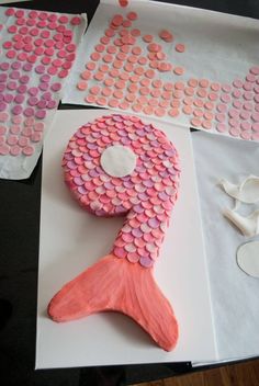 a cake made to look like a mermaid tail with pink and white dots on it