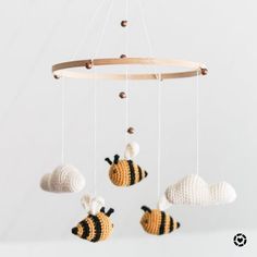 a crocheted mobile with three bees hanging from it