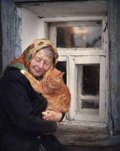 an old woman holding a cat in her arms