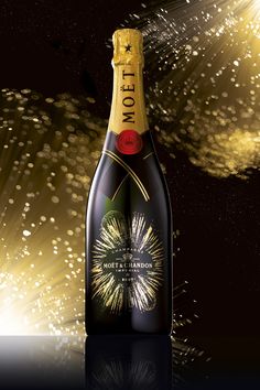 a bottle of champagne with fireworks in the background