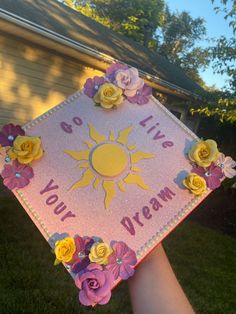 someone holding up a card with flowers on it that says do you live your dream?