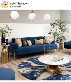 a living room filled with blue couches and gold accents on top of wooden floors