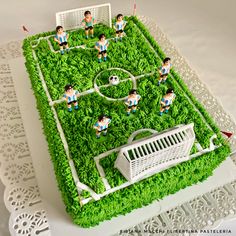 a cake made to look like a soccer field with people on it and a goalie in the middle