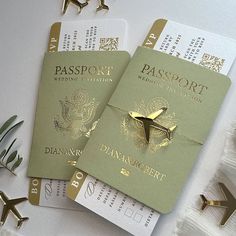 two green passports sitting next to each other on top of a white table with gold accents