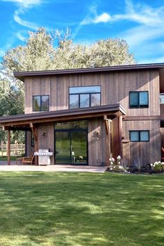 a large wooden house sitting on top of a lush green field