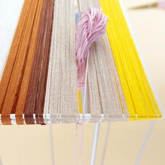 the table is made up of different colored strips of yarn and thread on top of each other