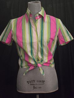 This 90's D & G pink, green, and white striped crop top is stunning and chic! In a crop top, tie waist style...The button up closure features little mother of pearl buttons with Dolce & Gabbano carved around the outside, see photos. The style is just so flattering and the craftsmanship is just wonderful! Perfect for that Summer cruise, Sunday brunch or beach picnic! by Dolce and Gabbana made in Italy size 30/44 size 8 US, see measurements below bust (or armpit to armpit: 19" waist: 17" length: approx 22" All measurements are taken flat... No signs of wear other than a little wrinkle here and there. Please feel free to message me with any questions and/or to request additional photos. 1980s Summer Fashion, 90s Crop Top, Summer Cruise, Striped Short, Striped Crop Top, Sunday Brunch, Beach Picnic, Mother Of Pearl Buttons, Pearl Buttons