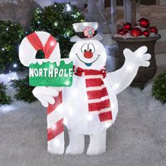 a snowman holding a sign that says north pole