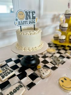 a birthday cake sitting on top of a table next to other cakes and cupcakes