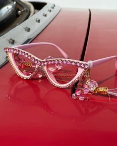 Dramatic, eye catching, and ultra fabulous, these Funnies are truly a MUST HAVE accessory! Surrounded by fun sparkly gold and pink rhinestones, the cat eye lenses are made in a dramatic pink hue. As if these glasses could be any more amazing, the stems have removable hanging crystal tassels at the temple that with eye-catching rhinestone beads. The not-so-subtle gold and pink neck chain can easily be removed. Guaranteed to bring the fabulous disco vibes with you everywhere you go, these out-of-t Disco Vibes, Eye Lenses, Hanging Crystal, People Happy, Gold And Pink, Fairy Godmother, Neck Chain, Novelty Items, Rhinestone Bead