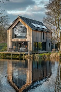 a house sitting on top of a lake next to a forest