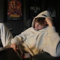 two young men sitting next to each other in front of a laptop computer on top of a desk