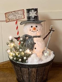 a snowman sitting in a bucket with lights