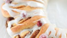 a pastry with icing and cranberries on it