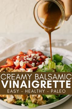 a bowl filled with salad and dressing being drizzled on top of it